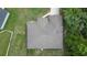 Aerial view of a house with a brown roof, a green yard, and surrounding trees at 144 Malauka Pass, Ocklawaha, FL 32179