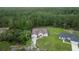 An aerial view showcasing the home's setting amidst a tranquil, tree-filled neighborhood with a spacious front yard at 144 Malauka Pass, Ocklawaha, FL 32179