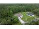 Aerial view of home and property in a lush wooded area at 144 Malauka Pass, Ocklawaha, FL 32179