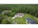 Expansive aerial view of a single-story home with a lush green lawn in a serene wooded neighborhood at 144 Malauka Pass, Ocklawaha, FL 32179