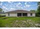 View of backyard and exterior of house with screened porch at 144 Malauka Pass, Ocklawaha, FL 32179