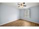 Bright bedroom boasts wood floors, a ceiling fan, and a window dressed with curtains at 144 Malauka Pass, Ocklawaha, FL 32179