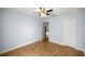 Bedroom with wood-look floors, ceiling fan, closet, and open door to another room at 144 Malauka Pass, Ocklawaha, FL 32179