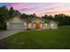 Charming single-story home featuring a manicured lawn, a two-car garage, and a welcoming coral-colored front door at 144 Malauka Pass, Ocklawaha, FL 32179
