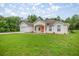 A charming single-story home with an attached garage and a well-maintained lawn provides inviting curb appeal at 144 Malauka Pass, Ocklawaha, FL 32179