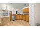 Bright kitchen featuring wood cabinets, stainless steel appliances, and a breakfast bar at 144 Malauka Pass, Ocklawaha, FL 32179