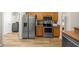 Kitchen featuring stainless steel appliances and wooden cabinetry, with a laundry room entrance at 144 Malauka Pass, Ocklawaha, FL 32179