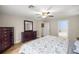 Main bedroom with wood-look floors, ceiling fan, and dresser, providing ample storage and style at 144 Malauka Pass, Ocklawaha, FL 32179