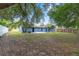 Spacious backyard with a newly painted blue home, open space and mature trees at 14761 Sw 35Th Terrace Rd, Ocala, FL 34473