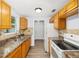 A well-lit kitchen with light wood cabinets, laminate countertops, stainless steel sink, and light wood flooring at 14761 Sw 35Th Terrace Rd, Ocala, FL 34473