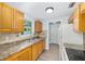 A well-lit kitchen with light wood cabinets, laminate countertops, stainless steel sink, and light wood flooring at 14761 Sw 35Th Terrace Rd, Ocala, FL 34473
