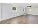 A spacious living room with two windows, ceiling fan, and light wood laminate flooring at 14761 Sw 35Th Terrace Rd, Ocala, FL 34473