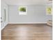 A spacious living room with two windows, ceiling fan, and light wood laminate flooring at 14761 Sw 35Th Terrace Rd, Ocala, FL 34473