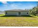 Back exterior of a one-story home with a large yard and a sliding glass door at 15212 Sw 27Th Ct, Ocala, FL 34473
