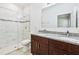 Bathroom featuring double sinks with granite counters and tiled glass door shower at 15212 Sw 27Th Ct, Ocala, FL 34473