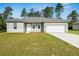 Inviting single-story home with a well-manicured lawn, a two-car garage, and neutral-colored exterior at 15212 Sw 27Th Ct, Ocala, FL 34473