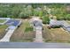 Aerial view of a single-Gathering home featuring a lawn, driveway, and mature trees at 15711 Sw 52Nd Avenue Rd, Ocala, FL 34473
