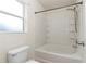 Clean white bathroom featuring a shower-tub combo and a window for natural light at 15711 Sw 52Nd Avenue Rd, Ocala, FL 34473