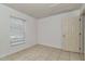 A tiled bedroom featuring a window with blinds and a door at 15711 Sw 52Nd Avenue Rd, Ocala, FL 34473