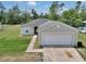 Exterior view of a charming single story home with a well-manicured lawn and an attached two-car garage at 15711 Sw 52Nd Avenue Rd, Ocala, FL 34473