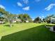 Expansive backyard with lush green grass, mature trees, and clear blue sky at 15822 Sw 16Th Avenue Rd, Ocala, FL 34473
