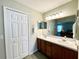 Bathroom features a double vanity with a large mirror, lighting and white closet at 15822 Sw 16Th Avenue Rd, Ocala, FL 34473