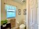 Well-lit bathroom featuring a toilet, window, and decorative elements with storage space at 15822 Sw 16Th Avenue Rd, Ocala, FL 34473