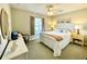 Cozy bedroom with a ceiling fan, bright decor, a window with curtains, and a comfortable bed at 15822 Sw 16Th Avenue Rd, Ocala, FL 34473