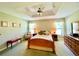 A primary bedroom boasts a tray ceiling, chair, and wooden furniture with lamps on the side tables at 15822 Sw 16Th Avenue Rd, Ocala, FL 34473