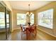 Bright breakfast nook with a wooden table, chandelier, and large windows overlooking the outdoor landscape at 15822 Sw 16Th Avenue Rd, Ocala, FL 34473