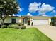 Charming home features a beautiful lawn, flower baskets, and a two-car garage at 15822 Sw 16Th Avenue Rd, Ocala, FL 34473