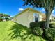 Manicured lawn and shrubbery surround the exterior of this house, under a clear blue sky at 15822 Sw 16Th Avenue Rd, Ocala, FL 34473