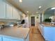 Bright kitchen with white cabinets, stainless steel sink, and an open view of the living area at 15822 Sw 16Th Avenue Rd, Ocala, FL 34473