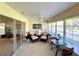 Bright sunroom featuring comfortable seating, a ceiling fan, and large windows overlooking the yard at 15822 Sw 16Th Avenue Rd, Ocala, FL 34473