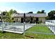 A view of the backyard with a pool, patio and white picket fence at 2201 Ne 45Th St, Ocala, FL 34479