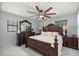 Elegant bedroom with dark wood furniture, white bedding, and a ceiling fan at 2201 Ne 45Th St, Ocala, FL 34479