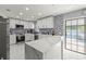 Modern kitchen featuring white marble floors, mosaic backsplash, a quartz island, and stainless steel appliances at 2201 Ne 45Th St, Ocala, FL 34479