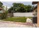 Home's backyard featuring a white fence, grass area, and walkway at 2563 Coral Ave, Kissimmee, FL 34741