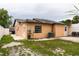 View of home's backyard with grass area and patio seating, surrounded by a white fence at 2563 Coral Ave, Kissimmee, FL 34741