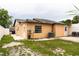 View of home's backyard with grass area and patio seating, surrounded by a white fence at 2563 Coral Ave, Kissimmee, FL 34741