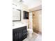 Bathroom features a walk-in shower, updated vanity, mirrored wall cabinet, and colorful shower curtain at 2563 Coral Ave, Kissimmee, FL 34741