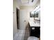 Bathroom with tiled floors, updated vanity and fixtures, and a doorway to the kitchenette at 2563 Coral Ave, Kissimmee, FL 34741