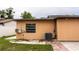 View of home's exterior featuring an AC unit, window and back patio area at 2563 Coral Ave, Kissimmee, FL 34741
