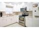 Modern kitchen with stainless steel appliances, white cabinets, and decorative tile backsplash at 2563 Coral Ave, Kissimmee, FL 34741