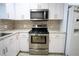 Compact kitchen featuring stainless steel appliances, granite counters and subway tile backsplash at 2563 Coral Ave, Kissimmee, FL 34741