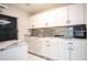 Well-organized kitchenette featuring white cabinetry with dark hardware, stylish countertops, and a subway tile backsplash at 2563 Coral Ave, Kissimmee, FL 34741