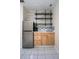 This kitchenette features stainless steel fridge, light wood cabinets, marble counter and backsplash, and floating shelves at 2563 Coral Ave, Kissimmee, FL 34741