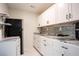 Efficient kitchenette featuring modern appliances, open shelving, ample counter space, and white cabinetry at 2563 Coral Ave, Kissimmee, FL 34741