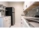 Charming kitchenette featuring open shelving, sleek black refrigerator, white cabinetry, and stylish countertops at 2563 Coral Ave, Kissimmee, FL 34741