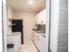 Compact kitchenette featuring white cabinets, sleek black hardware, black refrigerator, and marble-look countertops at 2563 Coral Ave, Kissimmee, FL 34741